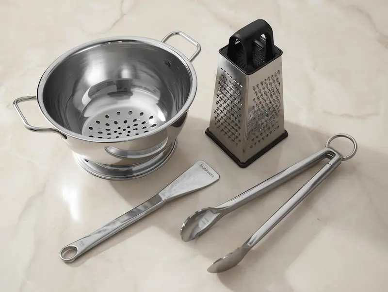 Passoire en inox, râpe à fromage et pince de cuisine
