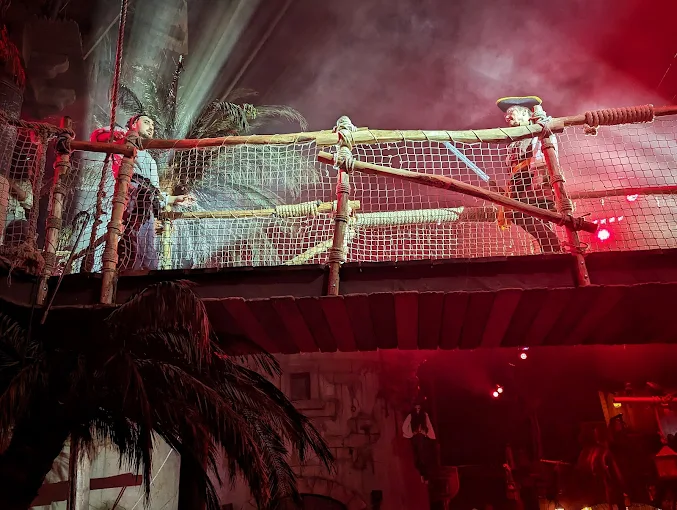 Passerelle et décors pirates avec lumières colorées et fumée au Pirate Paradise Montpellier