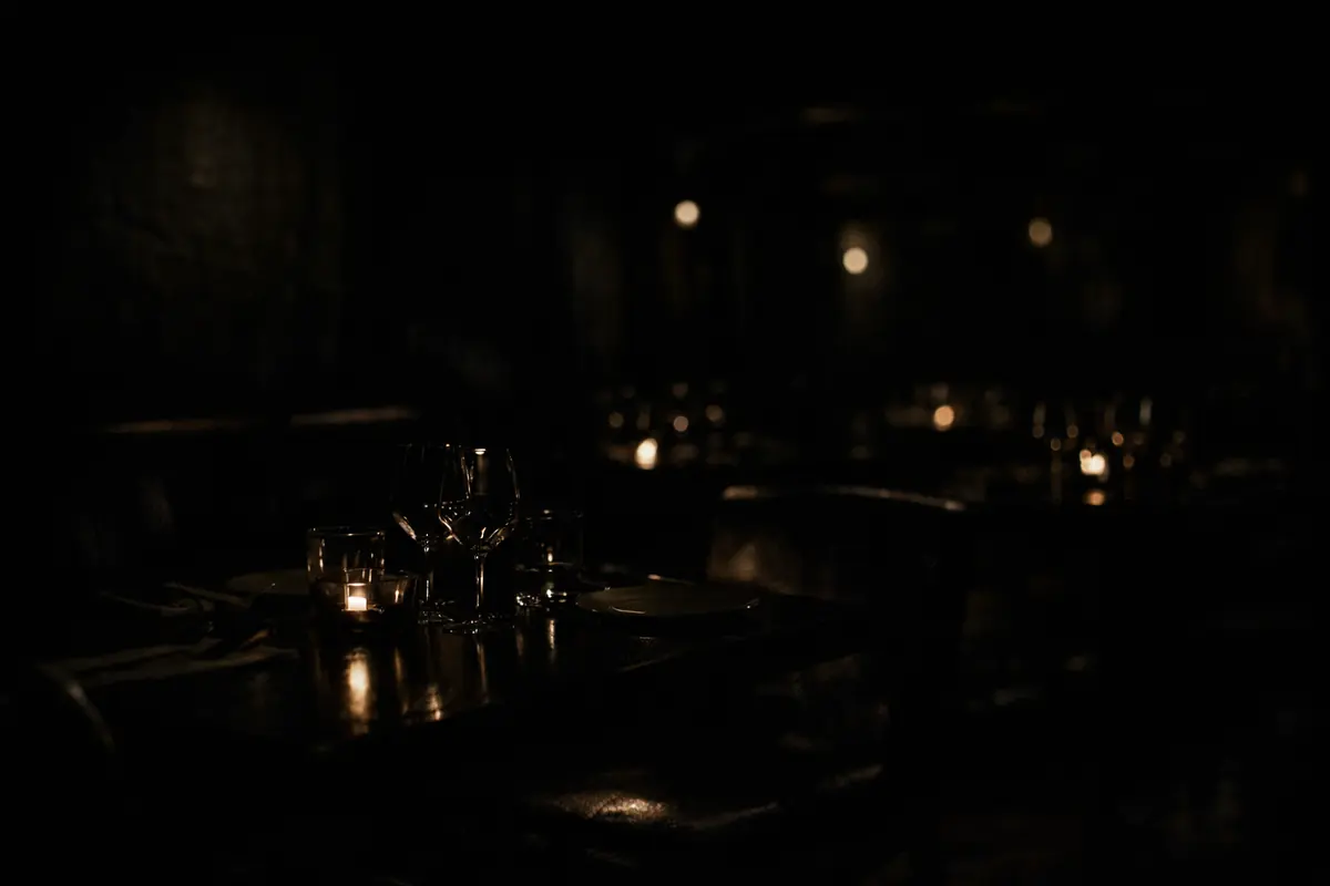 restaurant-insolite-paris-diner-dans-le-noir Intérieur du restaurant "Dans le Noir" à Paris, plongé dans une obscurité totale, expérience sensorielle unique.